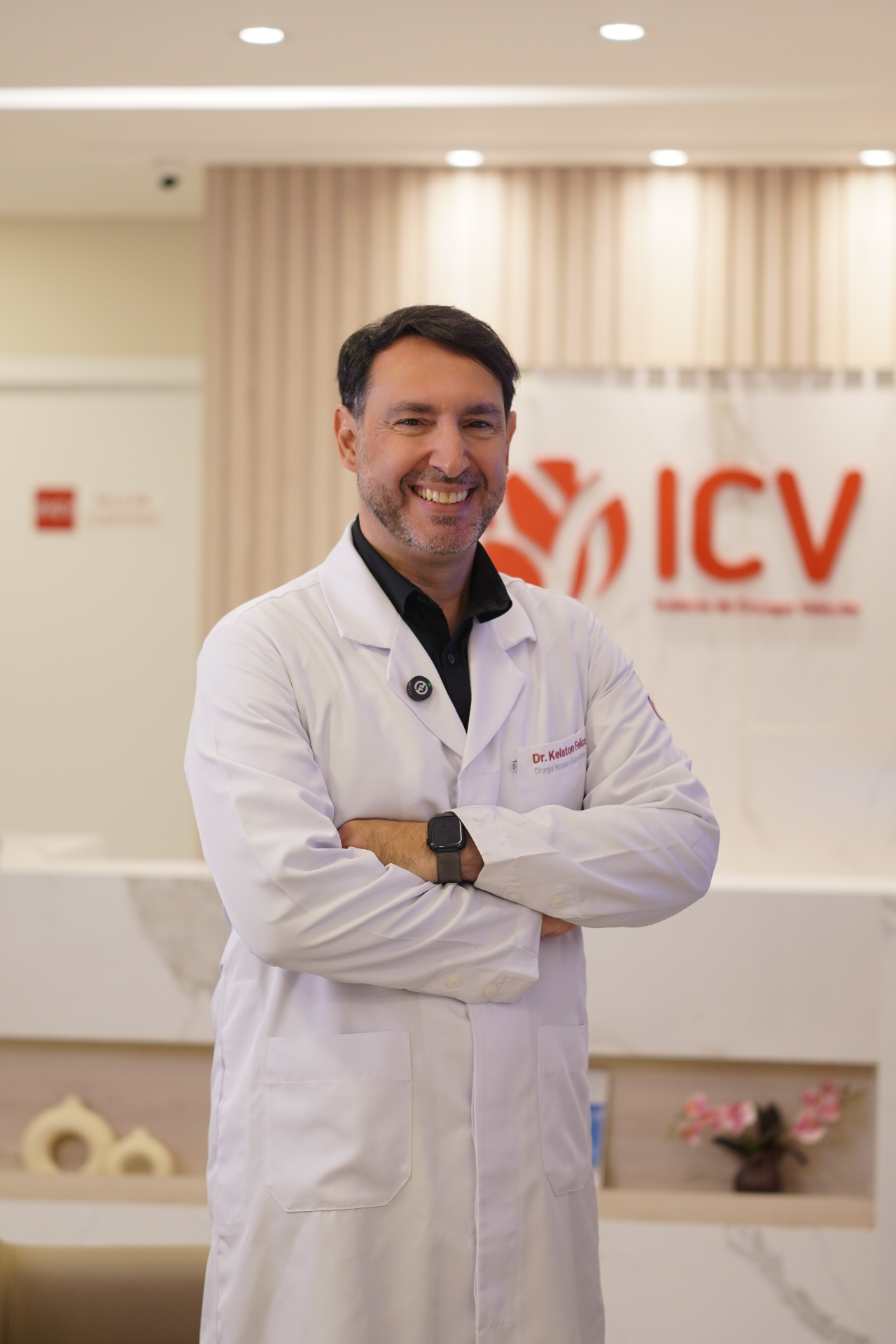 Dr. Kelston Felice, cirurgião vascular, em jaleco branco com braços cruzados no consultório do ICV em São Luís, MA