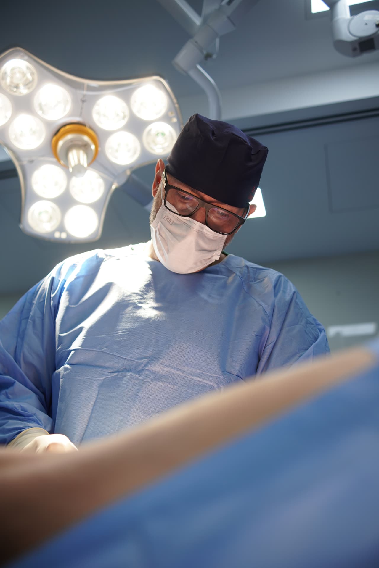 Cirurgião vascular paramentado durante procedimento em centro cirúrgico